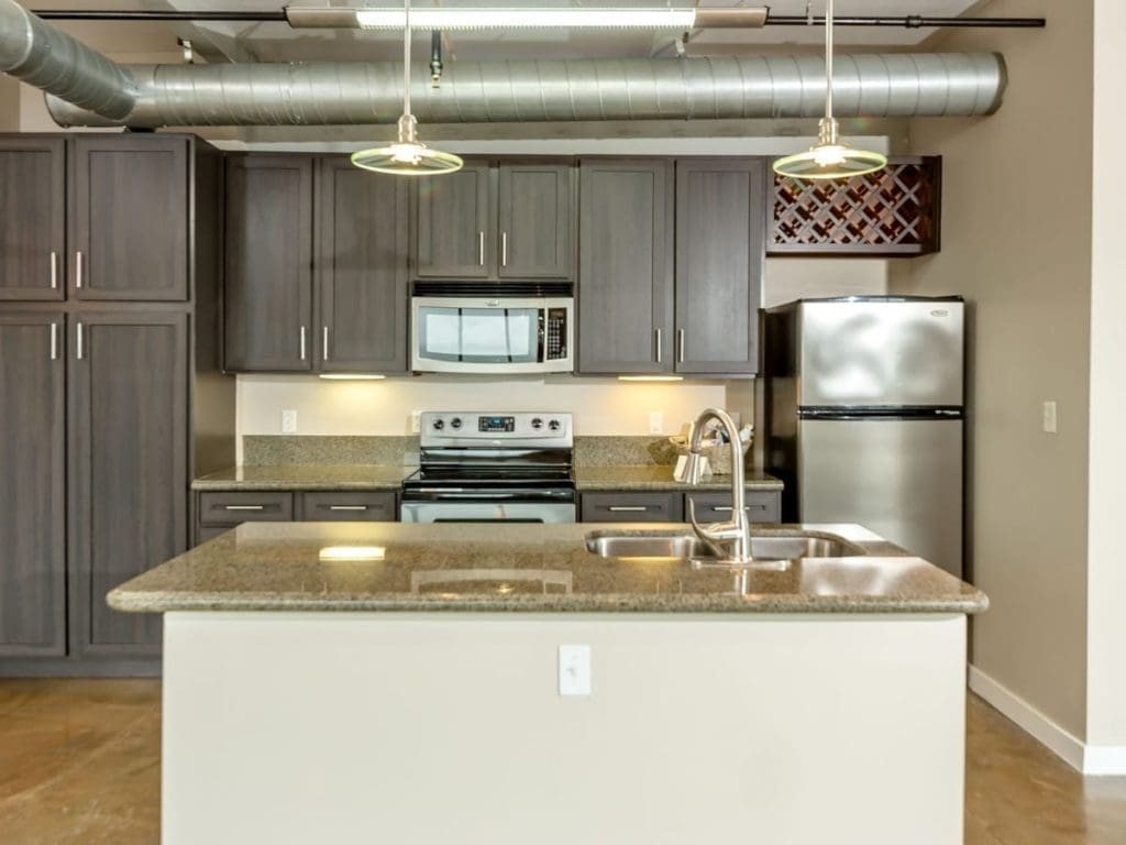 stunning kitchen with hanging lights, modern appliances, and a kitchen island